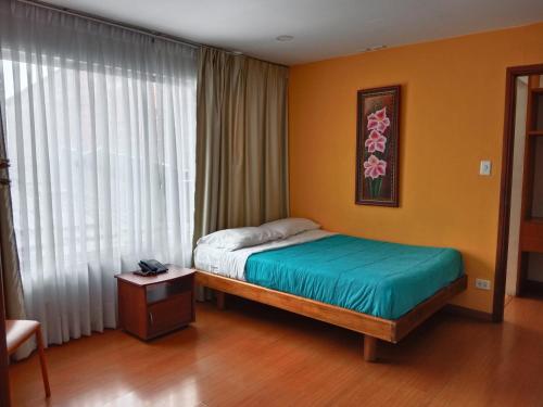 a bedroom with a bed and a large window at HBS Hotel in Manizales