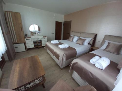 a hotel room with two beds and a table at ЕЛЕГАНС къща за гости in Dospat