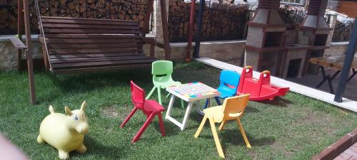 a group of chairs and a table and a bench at ЕЛЕГАНС къща за гости in Dospat