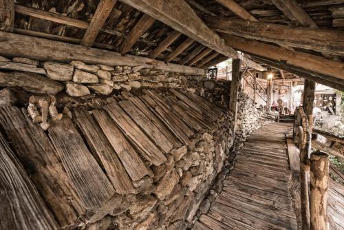 a room with a stone wall and a wooden floor at Der Verdinser Hof in Schenna