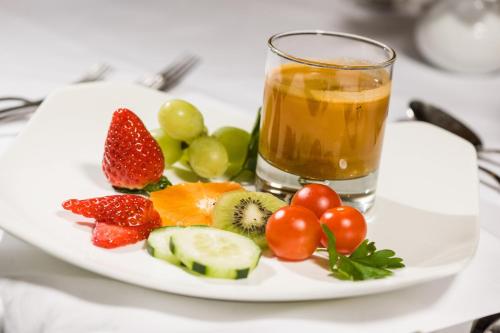 a plate of fruit and a glass of juice at Der Verdinser Hof in Schenna