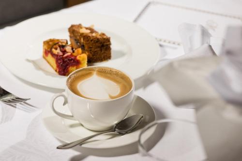 a cup of coffee and a piece of cake on a table at Der Verdinser Hof in Schenna