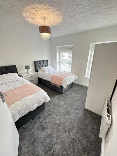 a bedroom with two beds and a chandelier at Cosy corner in Sligo