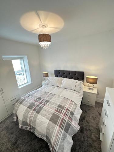a bedroom with a bed with a plaid blanket at Cosy corner in Sligo