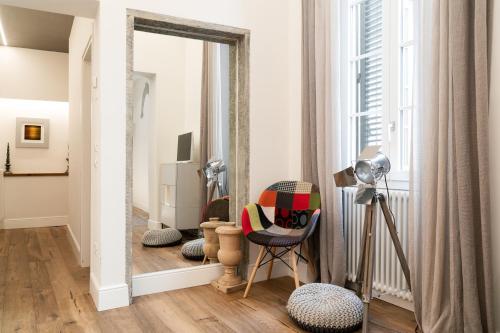 ein Wohnzimmer mit einem Spiegel und einem Stuhl in der Unterkunft Luxury Apartment - San Pancrazio, Florence in Florenz