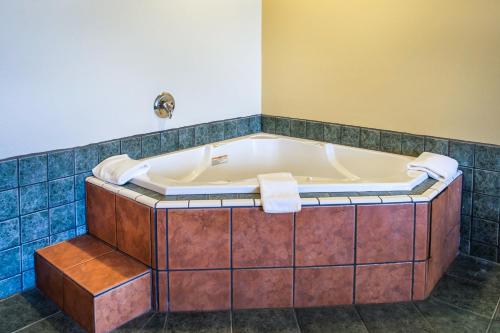 a bath tub in a bathroom with a tiled floor at Wingate by Wyndham Dublin Near Claytor Lake State Park in Dublin