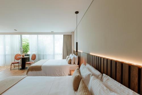 a hotel room with two beds and a large window at 1616 Hotel in Medellín