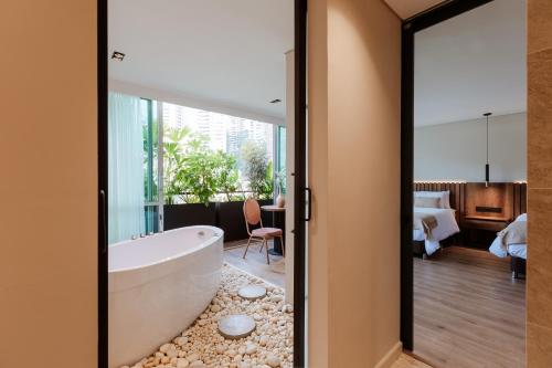 a bathroom with a tub and a bedroom at 1616 Hotel in Medellín