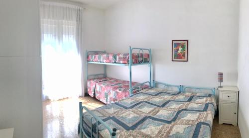 ビビオーネにあるCondominio Ovestのベッドルーム1室(二段ベッド2台、窓付)が備わります。