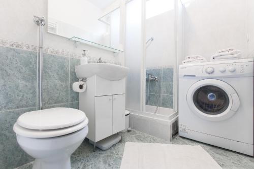 a bathroom with a toilet and a washing machine at Central point in Zagreb