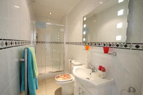 uma casa de banho com um lavatório, um WC e um espelho. em Arun Sands Rooms em Littlehampton