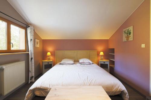 1 dormitorio con 1 cama grande y 2 mesas en Le Chalet Cosy piscine et spa, en Weiterswiller