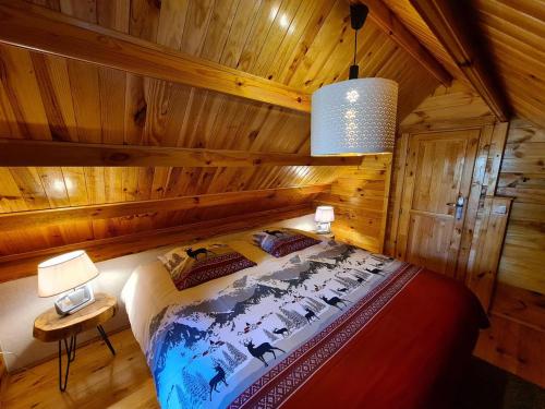 - une chambre avec un lit dans une cabane en bois dans l'établissement Le Chalet Aura et Jacuzzi, à Abreschviller