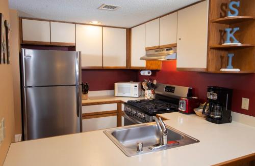 a kitchen with a stainless steel refrigerator and a sink at Winterplace on Okemo Mountain in Ludlow