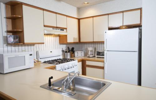 a kitchen with a sink and a white refrigerator at Winterplace on Okemo Mountain in Ludlow