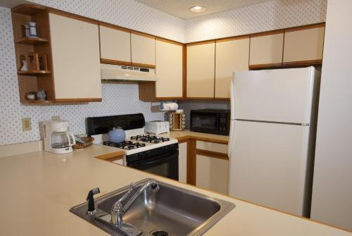 a kitchen with a white refrigerator and a sink at Winterplace on Okemo Mountain in Ludlow
