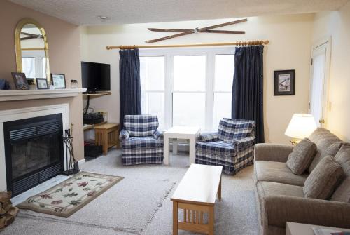 a living room with a couch and chairs and a fireplace at Winterplace on Okemo Mountain in Ludlow