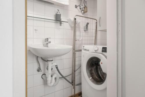 a bathroom with a sink and a washing machine at Comfortable 2BR Apt Central and Well Connected in Vienna