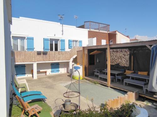a view of a yard with a house and a patio at MER 12 à 14 pers L'Aiguillon sur mer in LʼAiguillon-sur-Mer
