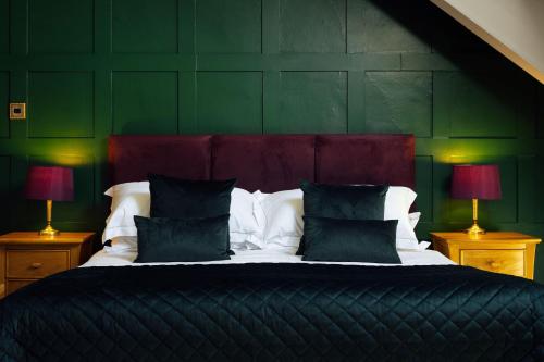 a bedroom with a large bed with two lamps at Elm Grove Country House in Tenby