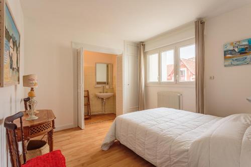 une chambre avec un lit, un bureau et un lavabo dans l'établissement Bel appartement en plein centre ville et 50 m de la grande plage, à Saint-Jean-de-Luz