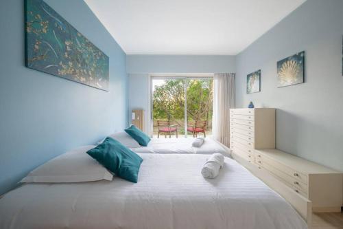une chambre avec un grand lit blanc et une fenêtre dans l'établissement Appartement familial 6P, avec piscine et tennis, proche mer, à Roquebrune-Cap-Martin