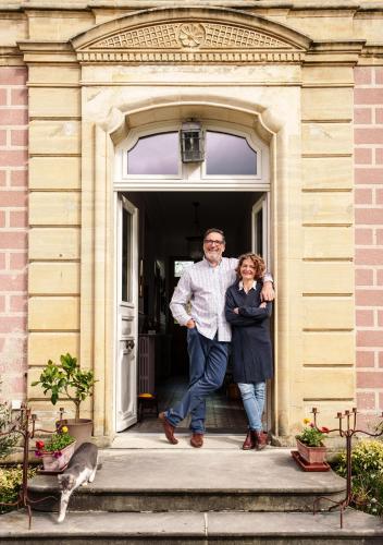 a man and a woman standing in the doorway of a house at La Cantellerie in Courseulles-sur-Mer