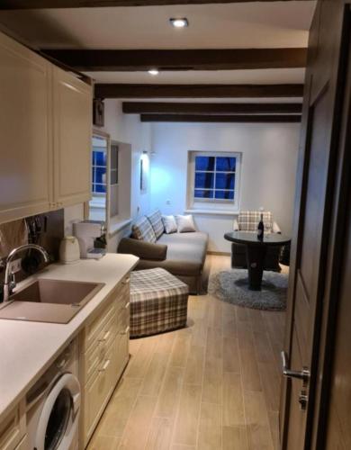 a kitchen and living room with a couch and a table at Preila Kristina-2 in Preila