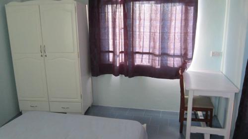 a small bedroom with a bed and a window at Aadi Villa in Mont Choisy
