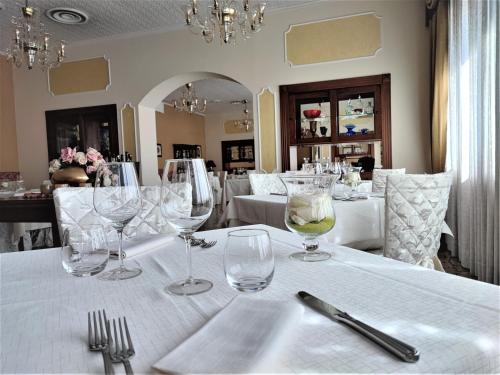 un tavolo con bicchieri da vino su una tovaglia bianca di Hotel Poppi a Mira
