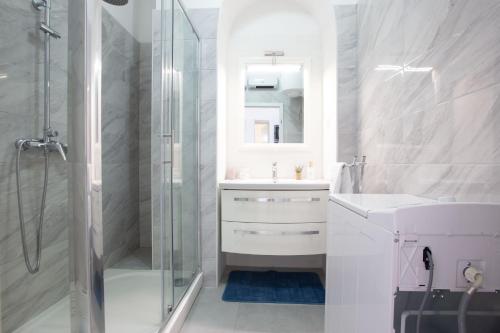 een witte badkamer met een wastafel en een douche bij MS 3BR Apartment near Kolovare beach in Zadar