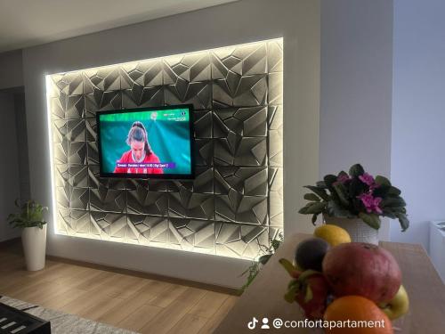 a tv mounted on a wall in a living room at Confort Apartament in Ploieşti