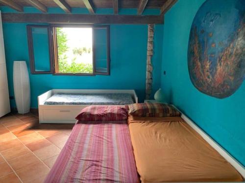 a bed in a room with a window at Villa Maveda, un dammuso immerso nel verde in Lampedusa