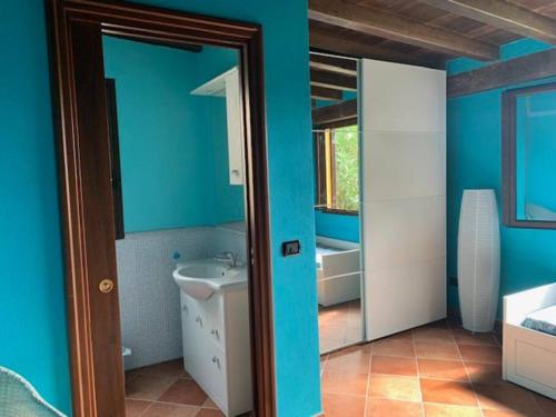 a bathroom with blue walls and a sink and a mirror at Villa Maveda, un dammuso immerso nel verde in Lampedusa