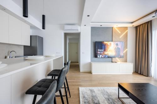 a kitchen and living room with a table and chairs at Terra Luxe Residences in Sajmište