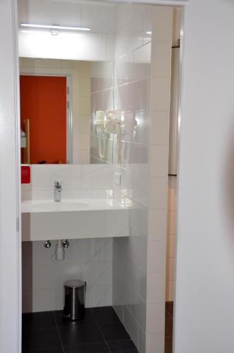 a bathroom with a sink and a mirror at Auberge des 3 Fontaines in Brussels