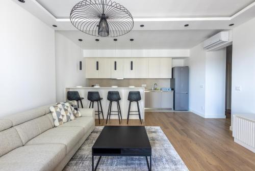 a living room with a couch and a kitchen at Terra Luxe Residences in Sajmište