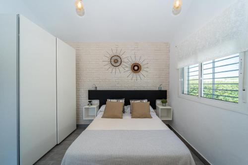 a white bedroom with a large bed and a window at Apartamento Jibazahora Escorpio in Zahora