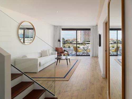 a living room with a white couch and a mirror at H10 Atlantic Sunset Horizons Collection in Adeje