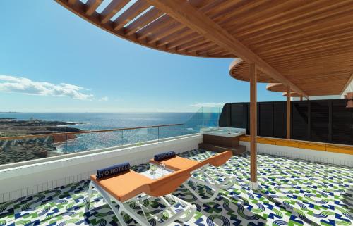 a balcony with two chairs and a view of the ocean at H10 Atlantic Sunset Horizons Collection in Adeje