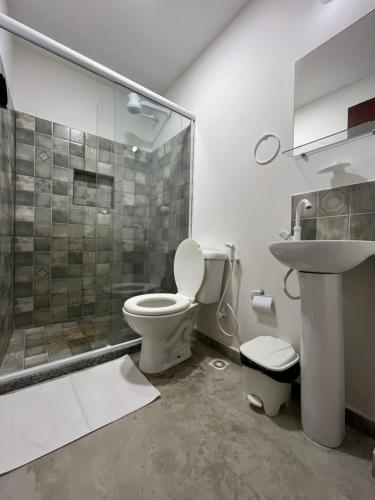 uma casa de banho com um chuveiro, um WC e um lavatório. em Hospedagem Pé Na Areia em Arraial do Cabo