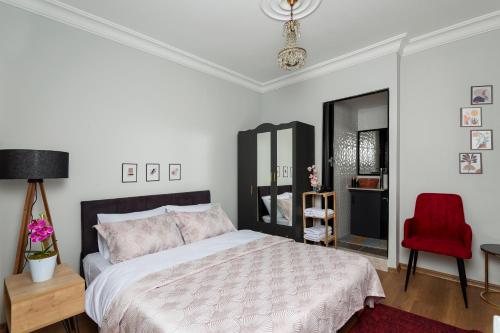 a bedroom with a bed and a red chair at 8 Rooms House in Balcova