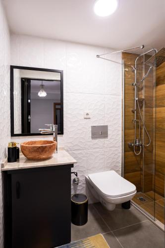 a bathroom with a sink and a toilet and a mirror at 8 Rooms House in Balcova