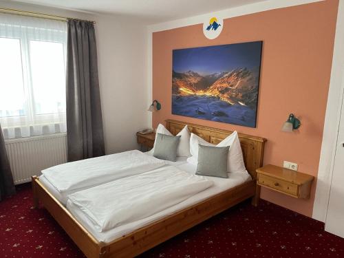 a bedroom with a large bed with white sheets at Hotel Solaria in Obertauern