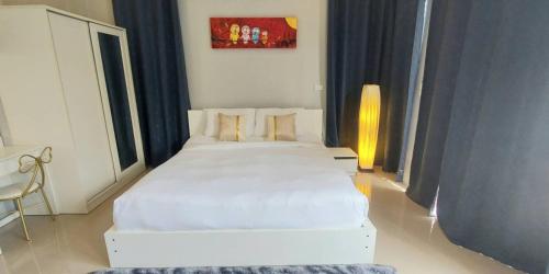 sypialnia z dużym białym łóżkiem w pokoju w obiekcie Patrick villa phuket w mieście Bang Tao Beach