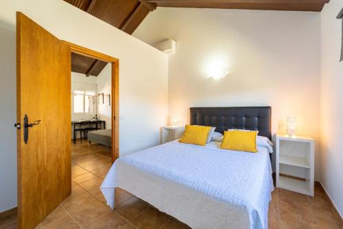 1 dormitorio con 1 cama con almohadas amarillas en Apartamento Jibazahora Tauro, en Zahora