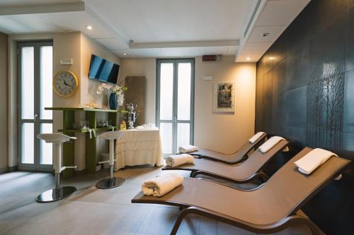 een woonkamer met 2 stoelen en een klok bij Parini Hotel in Bosisio Parini