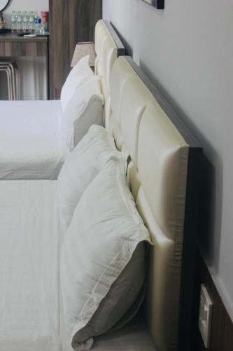 a row of beds with white sheets and pillows at HAPPY HOTEL Tp Rạch Giá, Kiên Giang in Ấp Rạch Mẹo