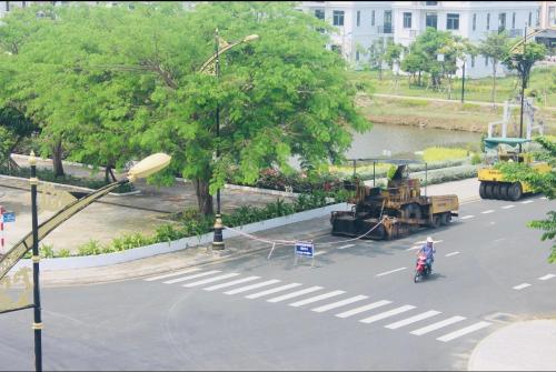 a man on a motorcycle in a street with a tractor at HAPPY HOTEL Tp Rạch Giá, Kiên Giang in Ấp Rạch Mẹo