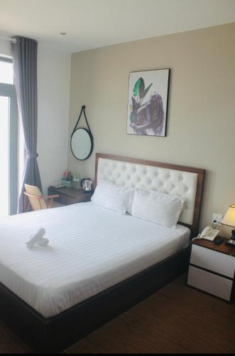 a bedroom with a bed and a desk and a window at HAPPY HOTEL Tp Rạch Giá, Kiên Giang in Ấp Rạch Mẹo